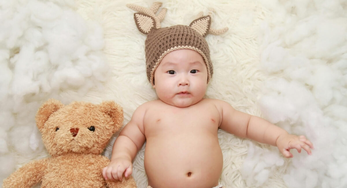Neugeborenes in einer Mütze, als Darstellung für Baby Kleidung Größentabelle