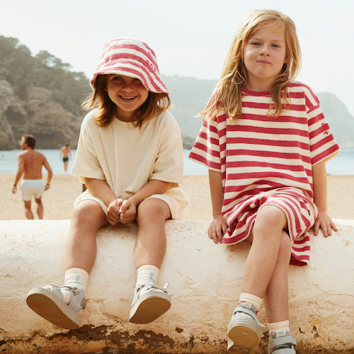 Zwei Mädchen am Strand, angezogen in Fair Trade Kinderkleidung